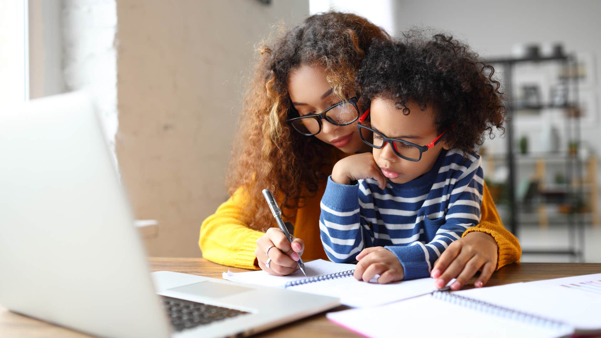 Woman helping her young son with his homework