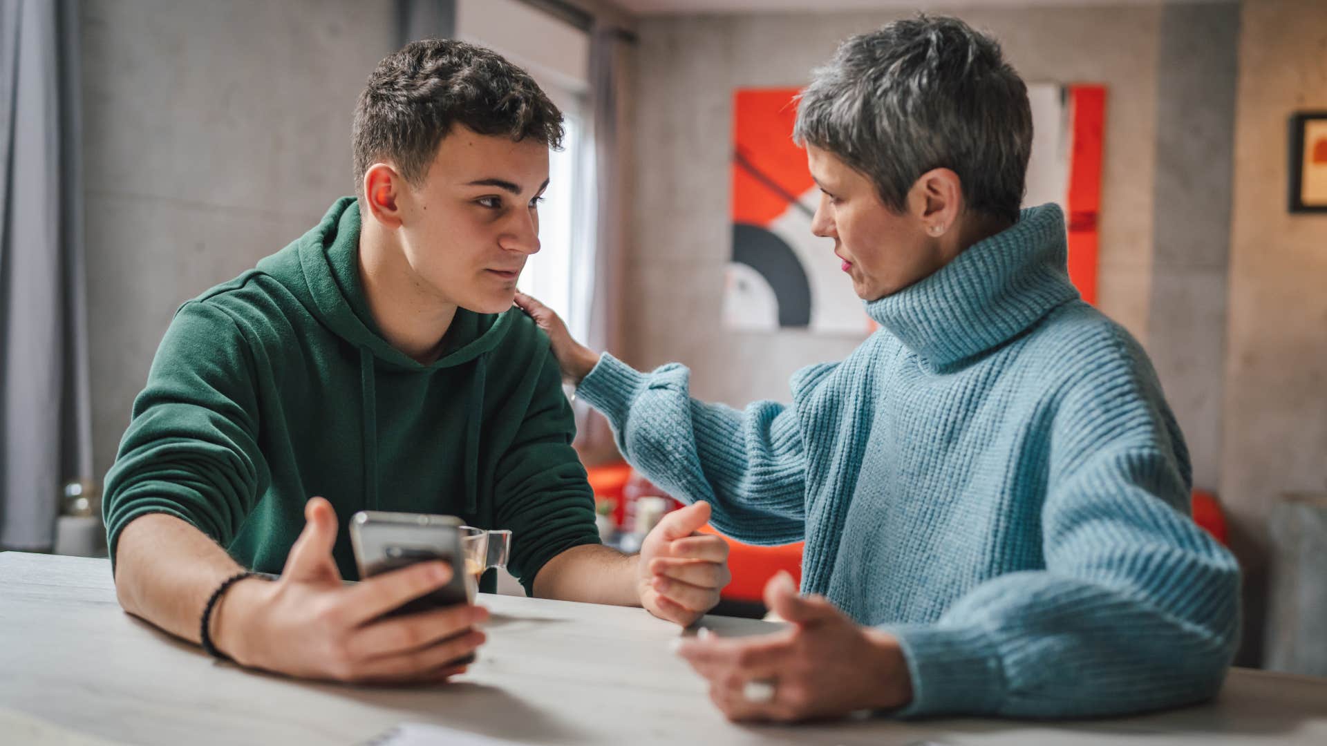 Teenage boy talking to his mom at home