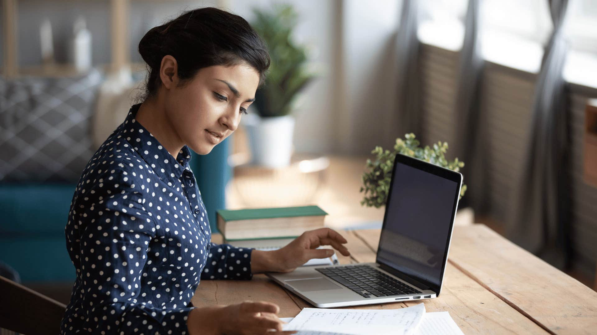 woman on laptop taking notes