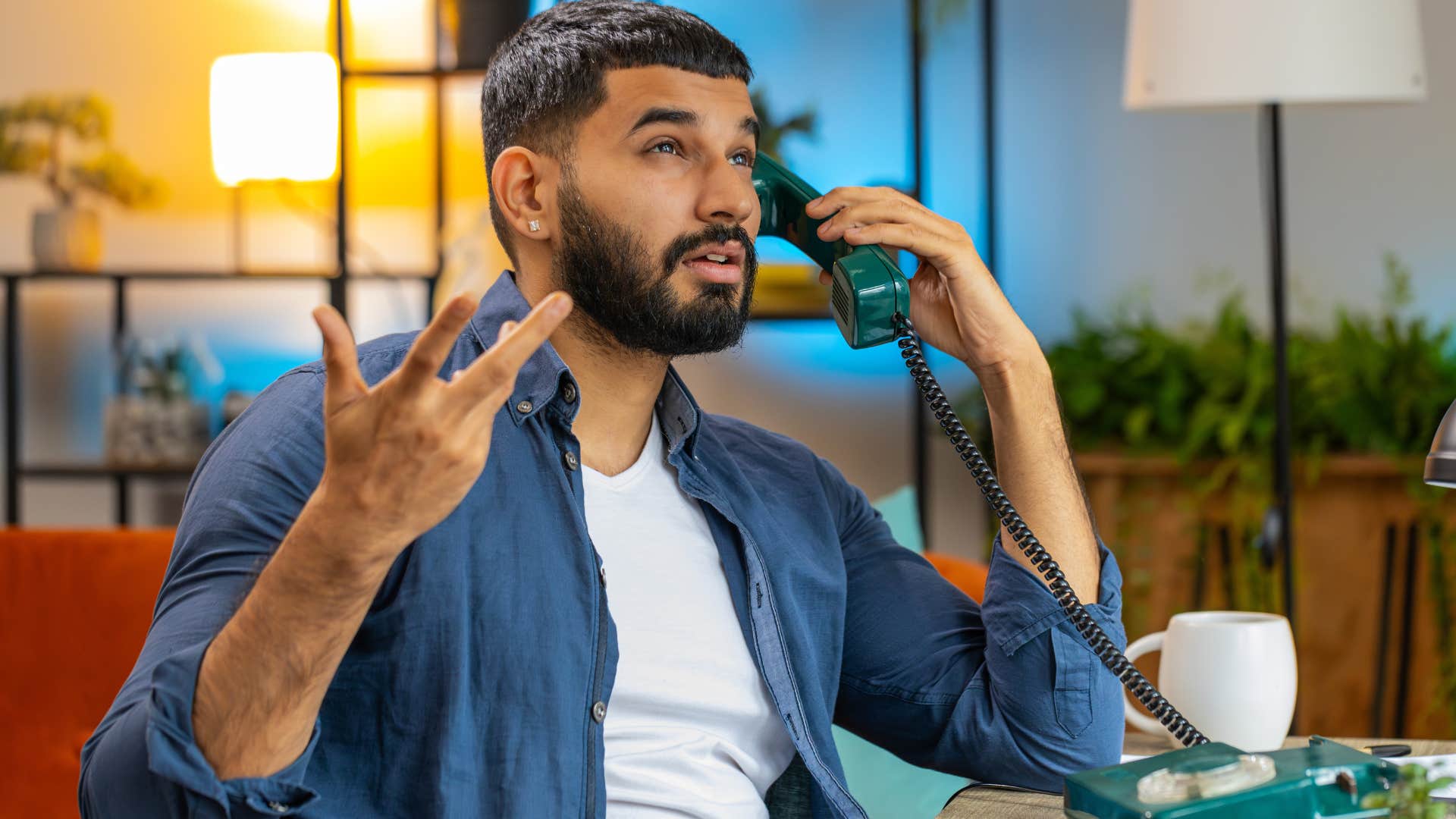 man looking defensive while talking on the phone