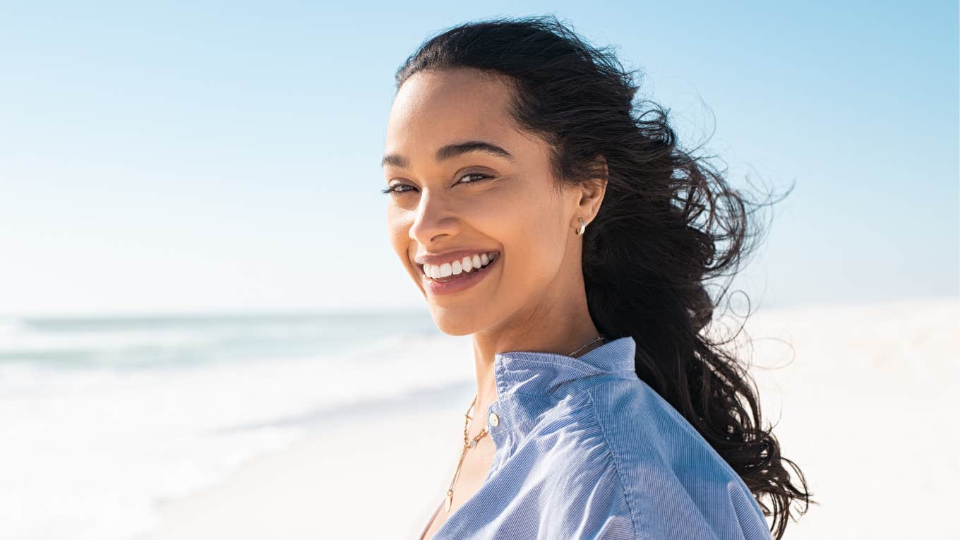 Woman smiling while standing on beach