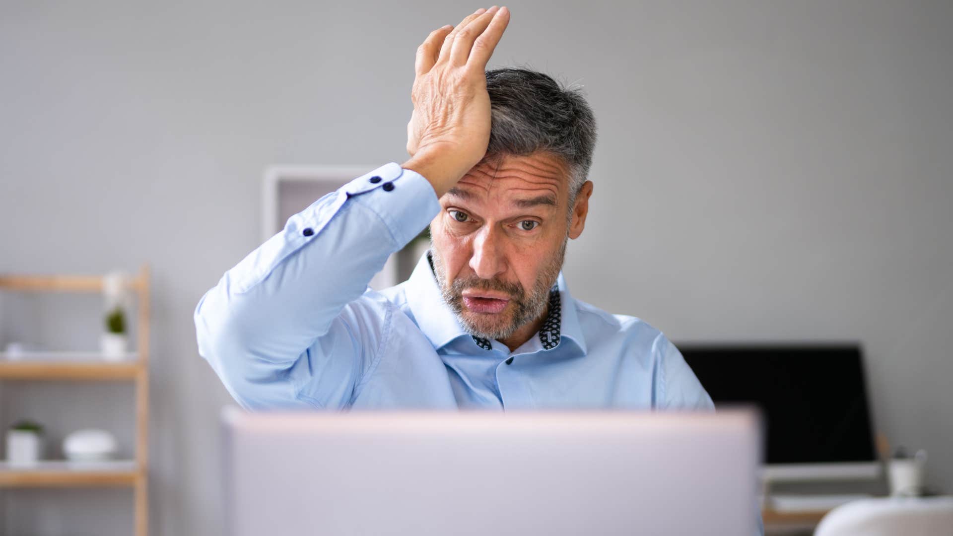 Boomer man looking frustrated staring at his laptop