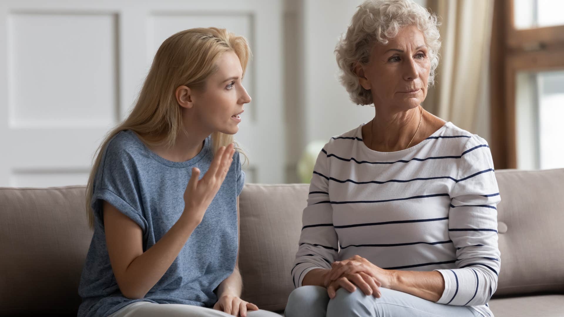 Adult daughter arguing with her mother on the couch