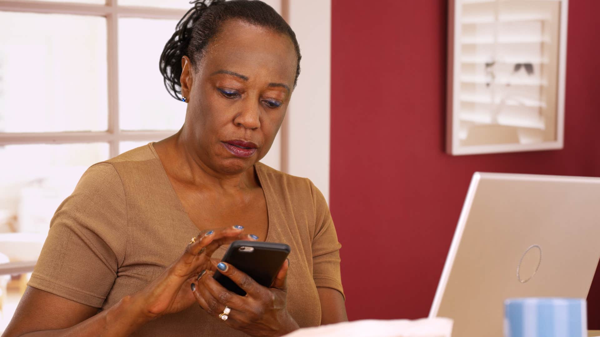 Older woman looking annoyed texting on her phone