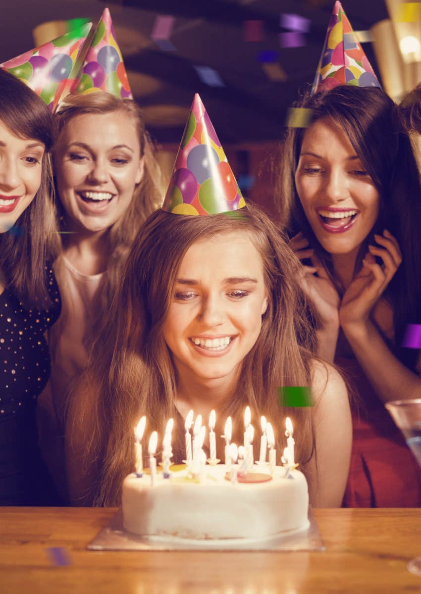 Woman blowing out the candles at her birthday party