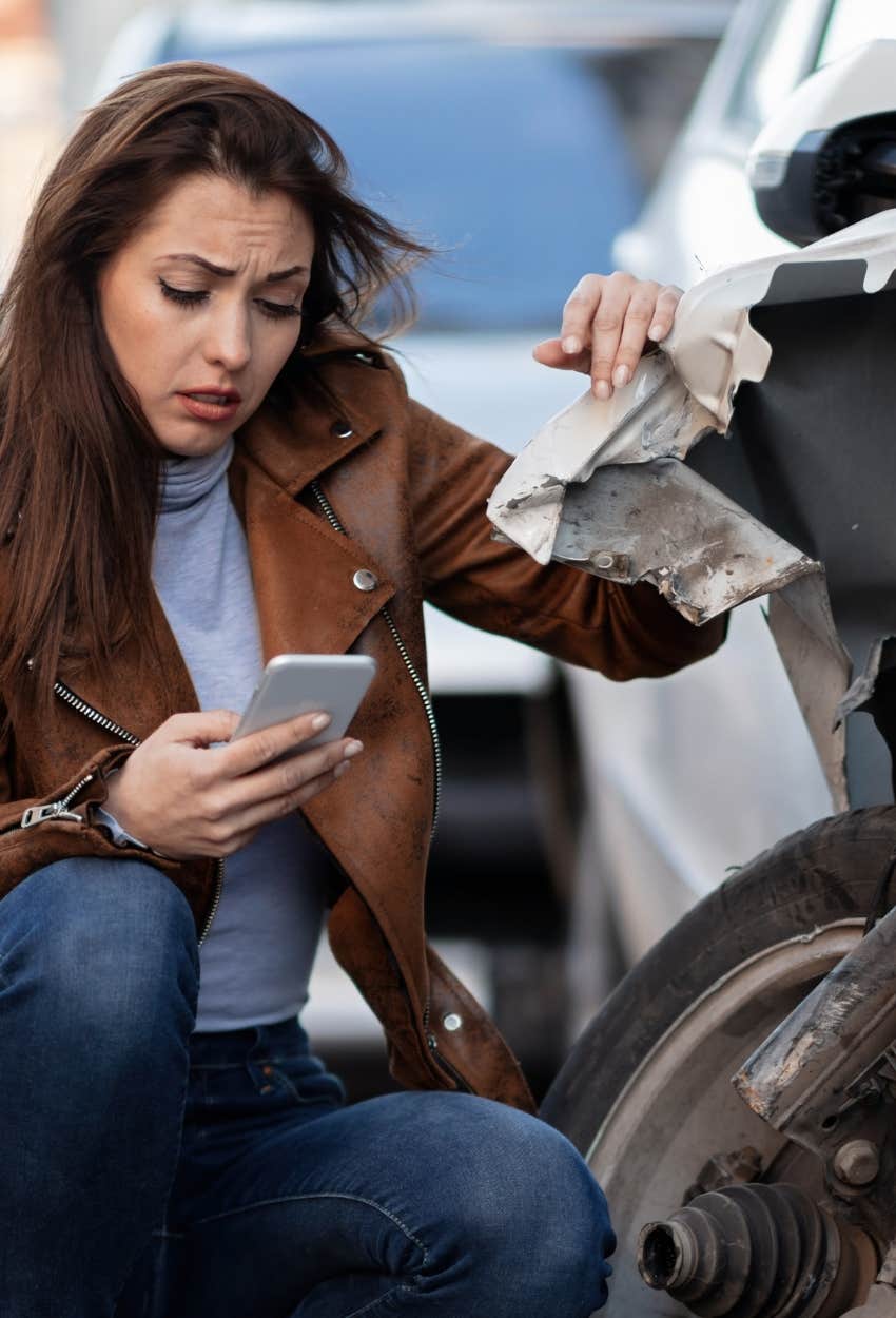 woman assessing damage from accident in parking lot