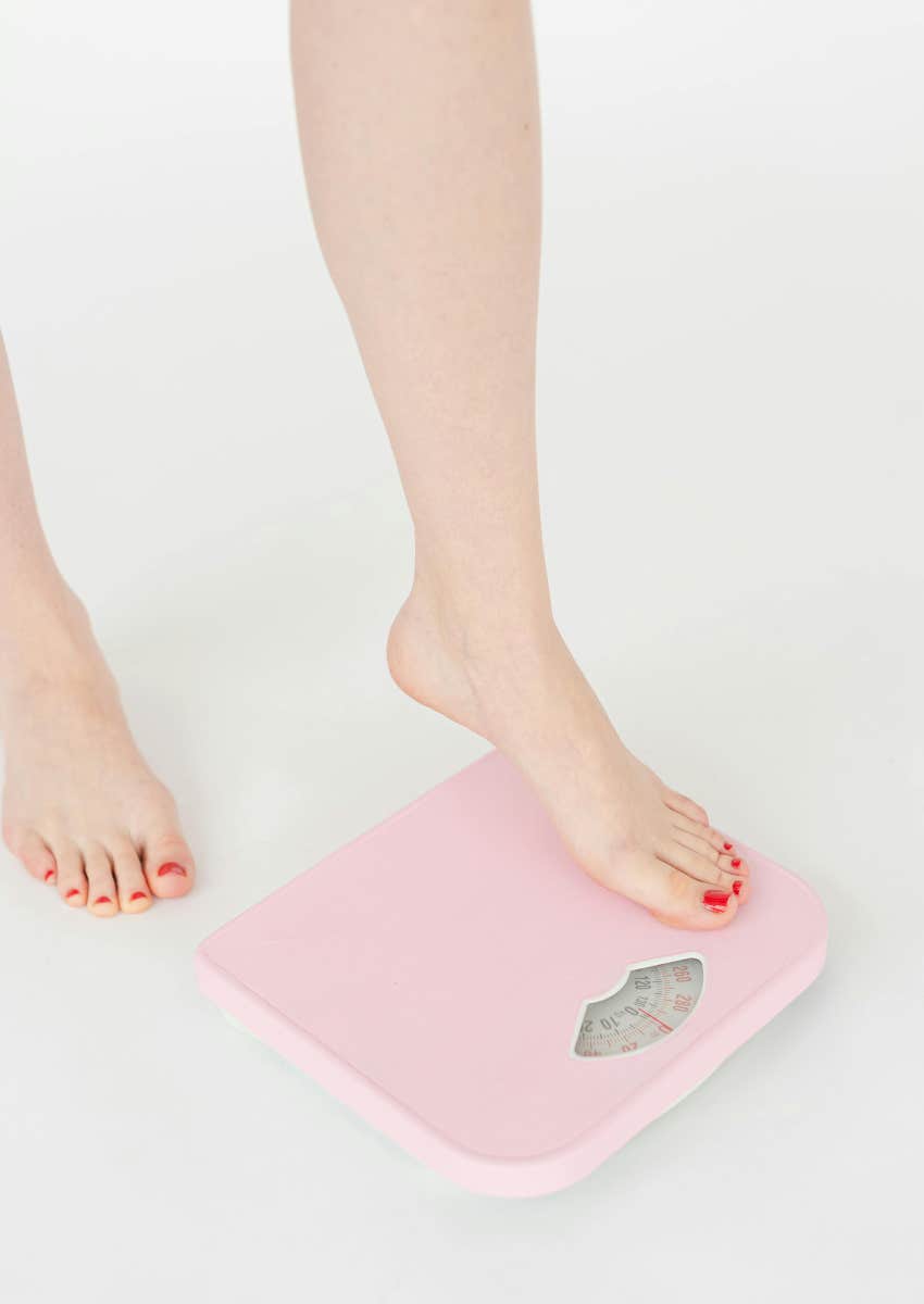 woman stepping onto pink scale