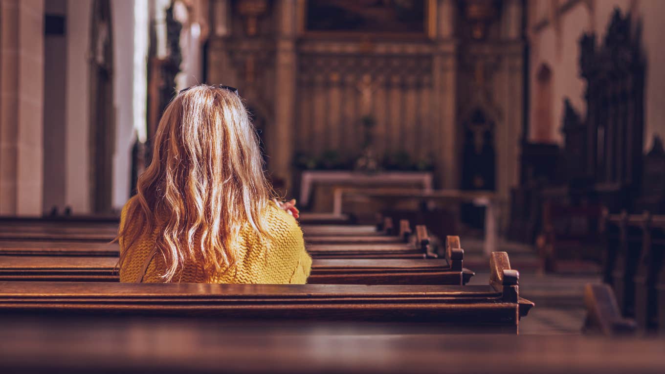 Young woman praying and meditating in church