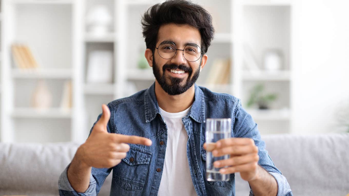 smiling man holding glass of water