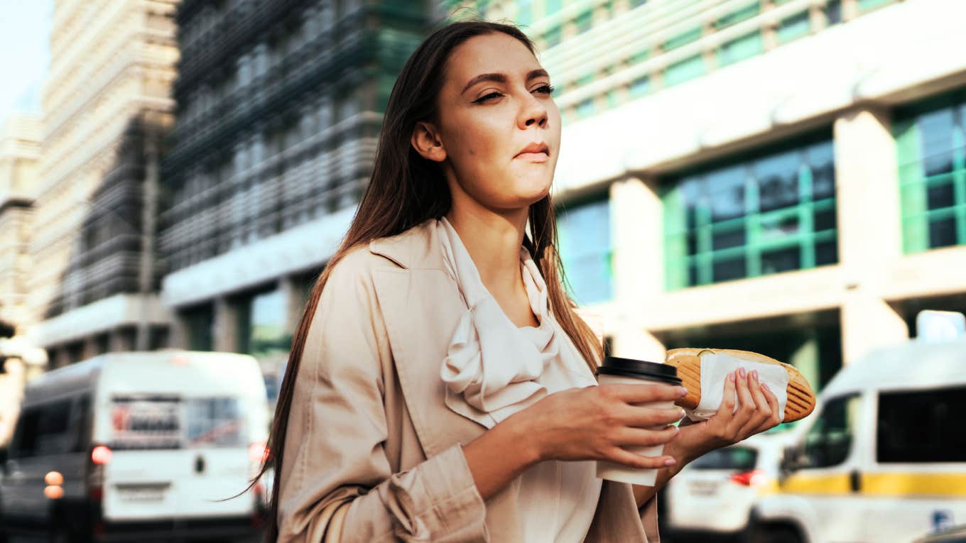 Woman eating while on her way to work.