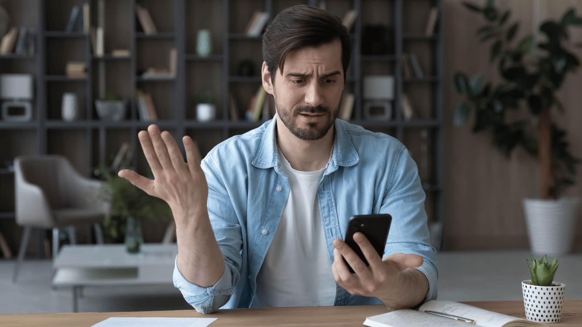 man staring at his phone in disbelief