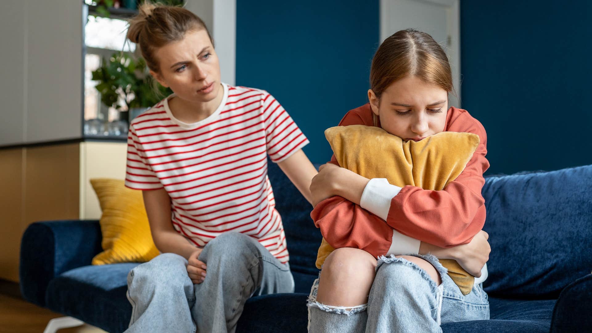 Woman comforting her upset teenage daughter.