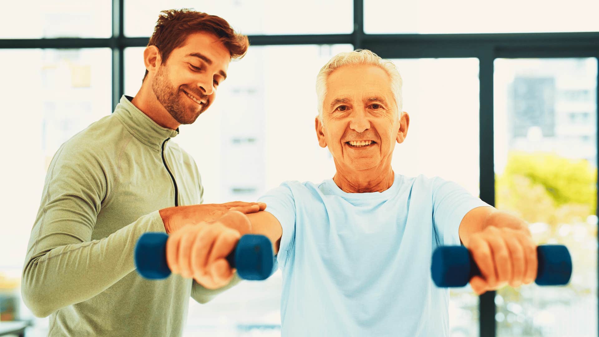 man helping an older man exercise