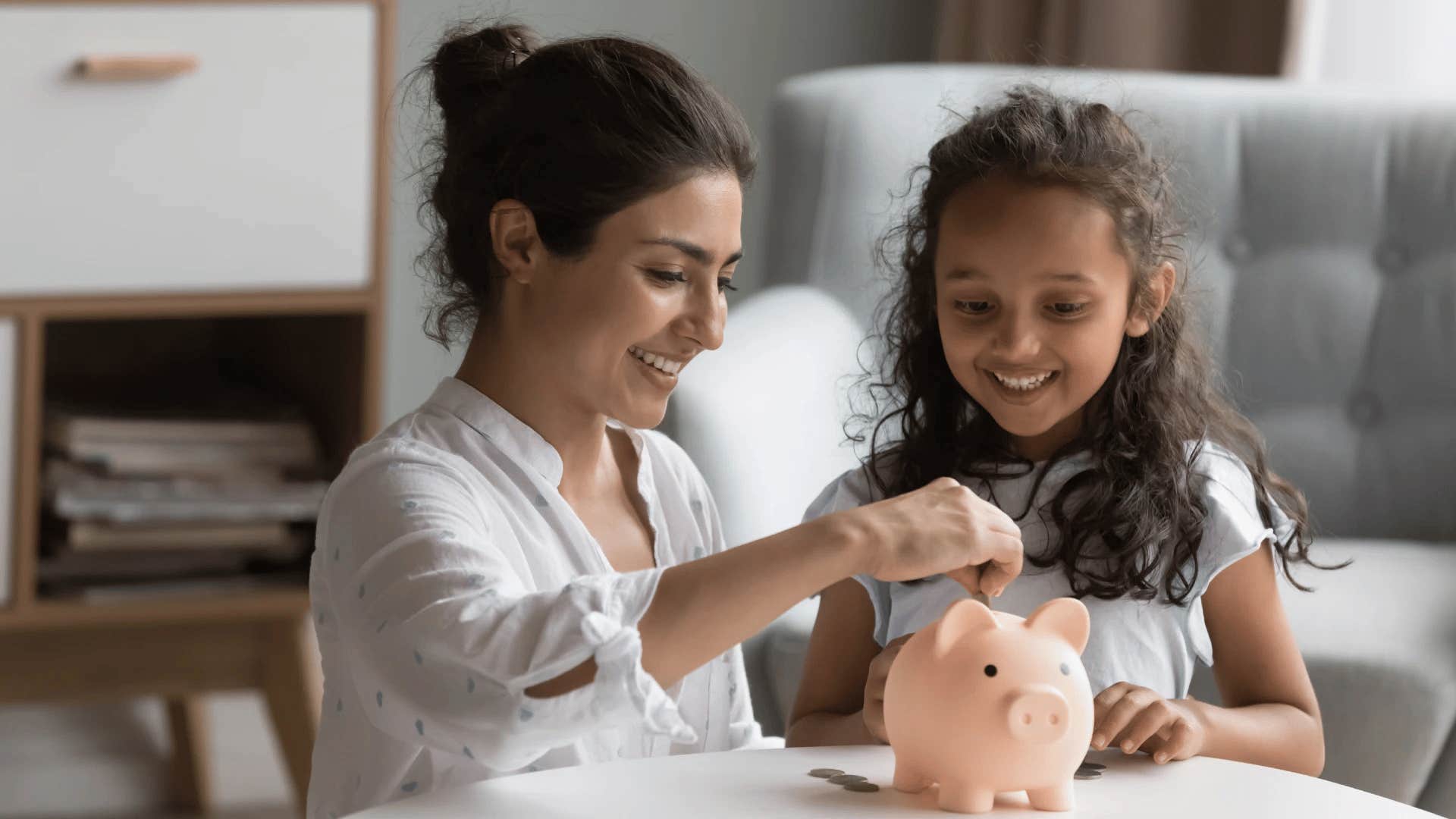 mother teaching daughter to save money