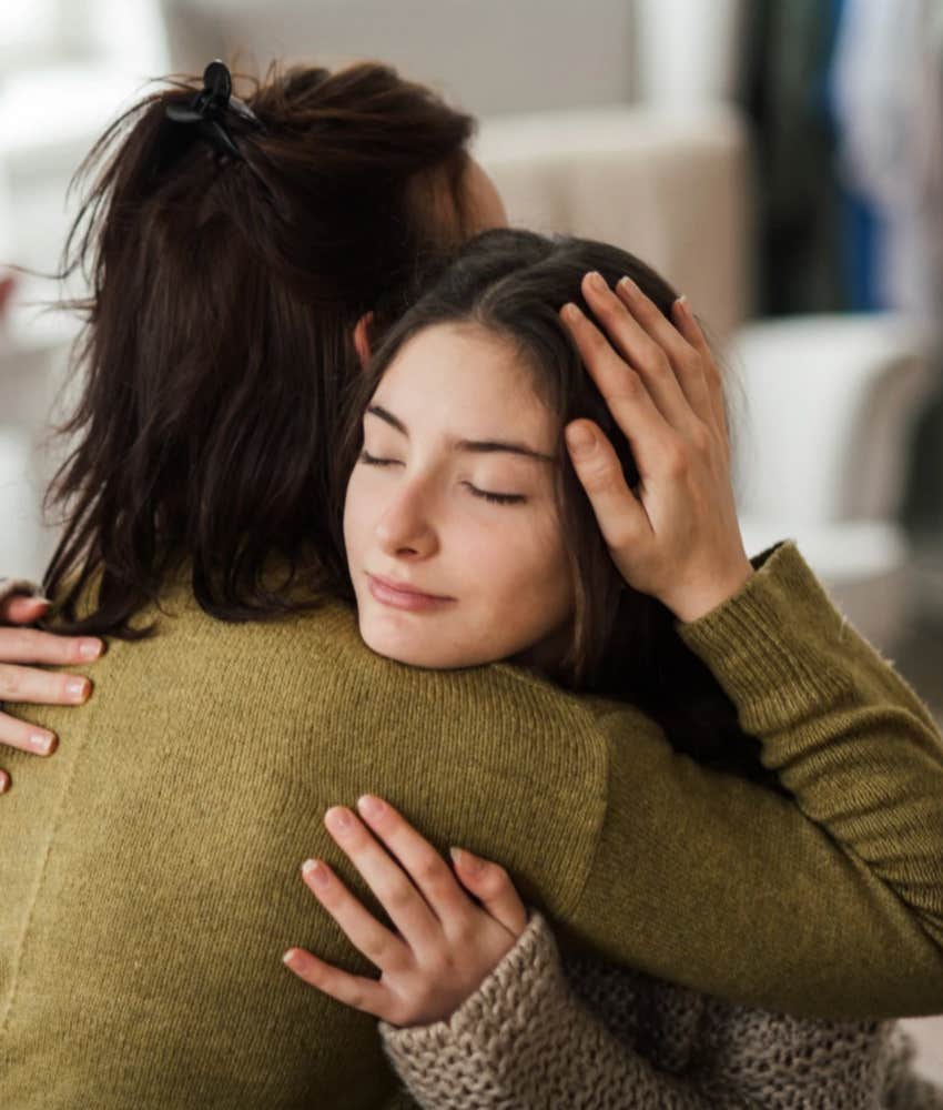 Mom hugging teen daughter remembering what it's like to be young 