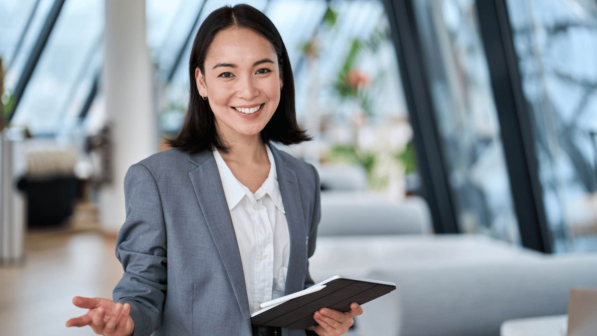 woman smiling while holding tablet 