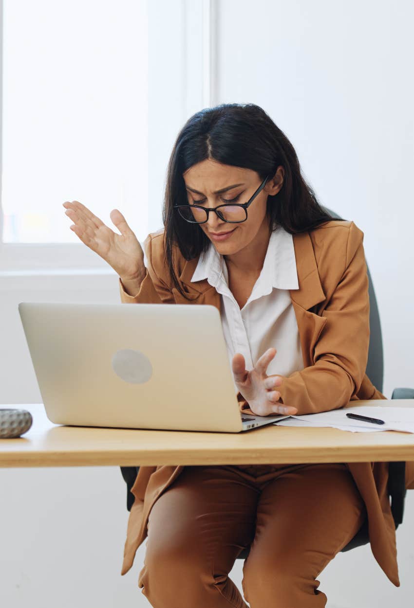 Annoyed woman writing email telling someone mind business