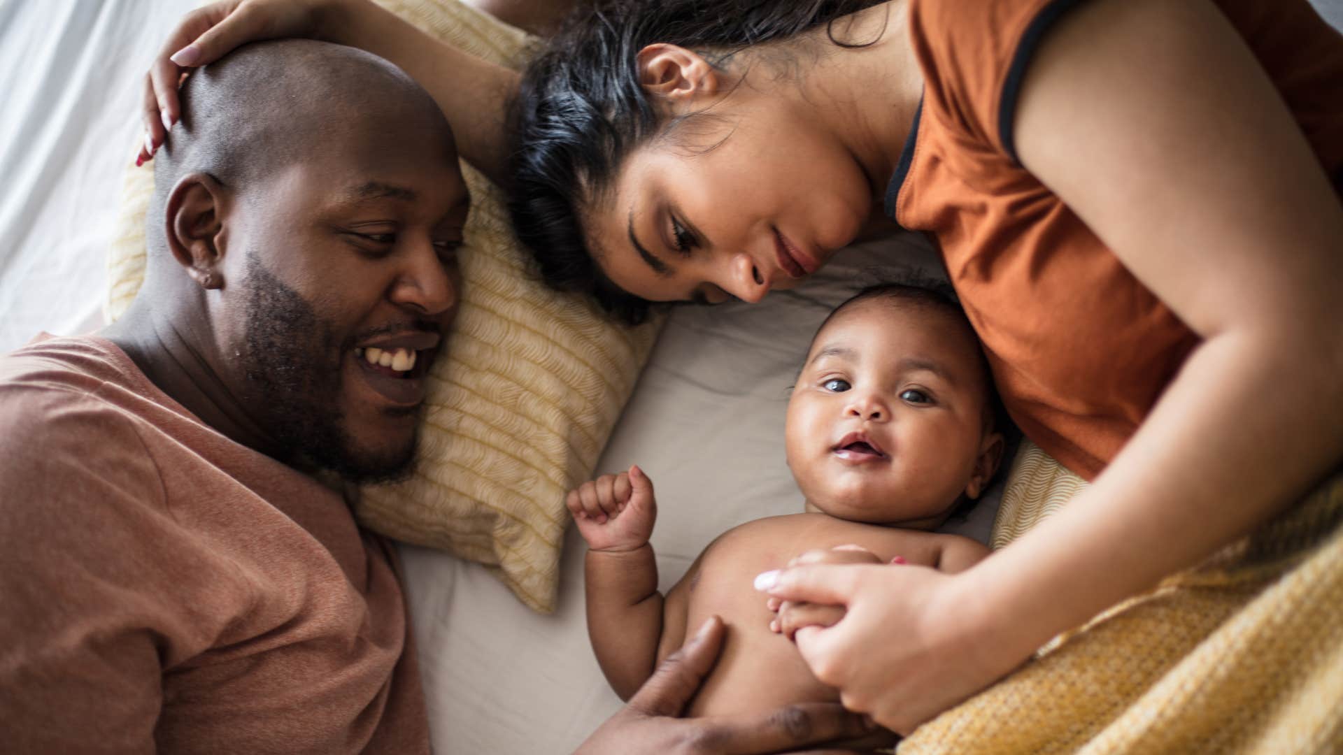 parents with daughter on bed