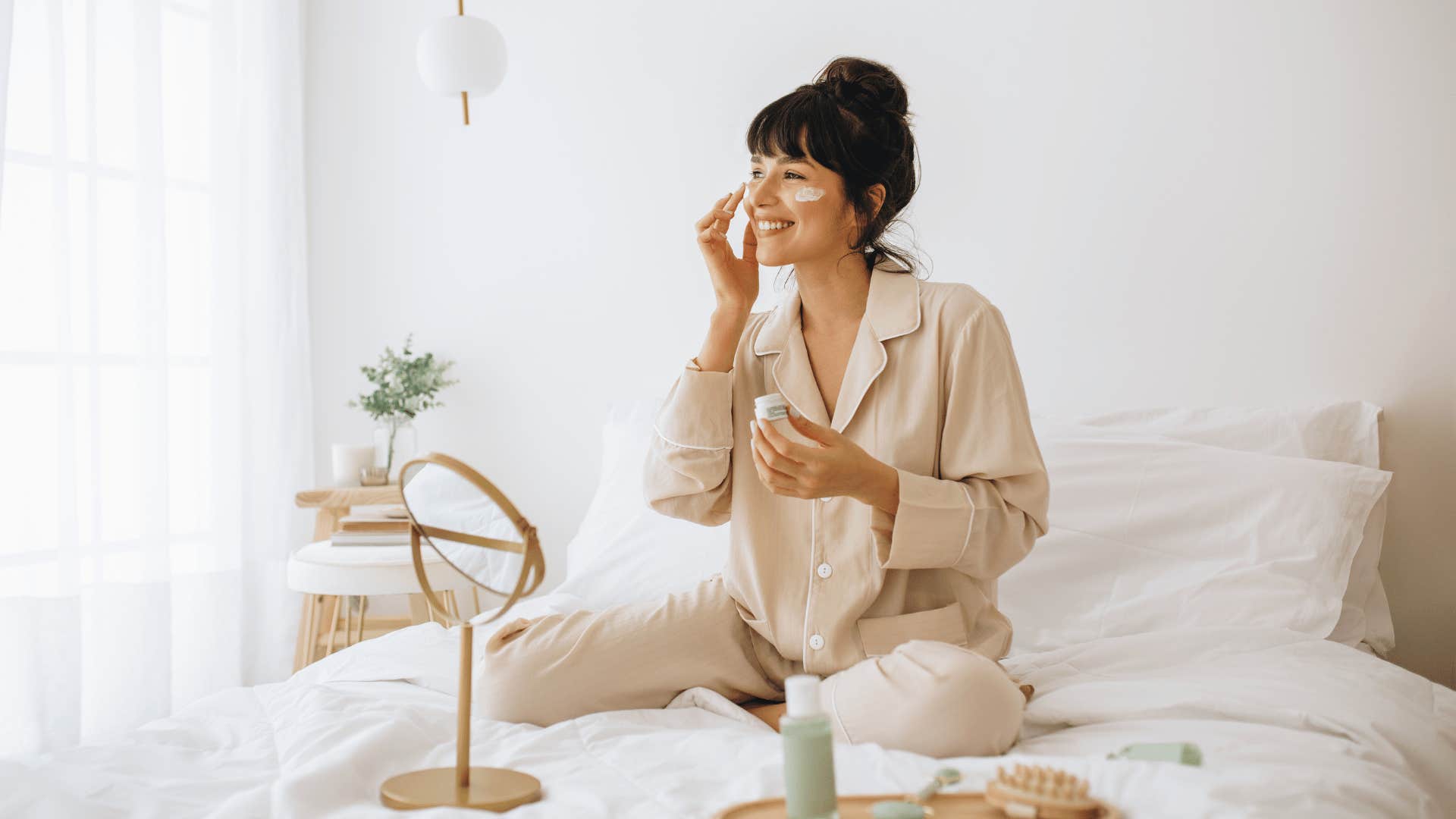 woman doing skincare in bed