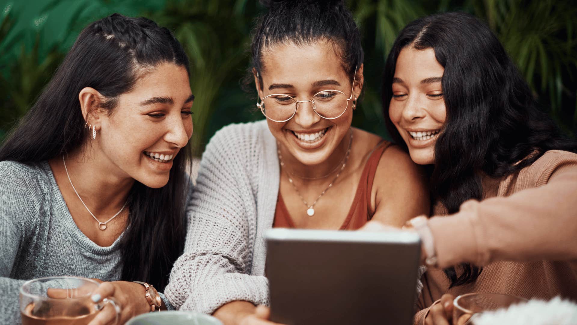 friends looking and smiling at tablet