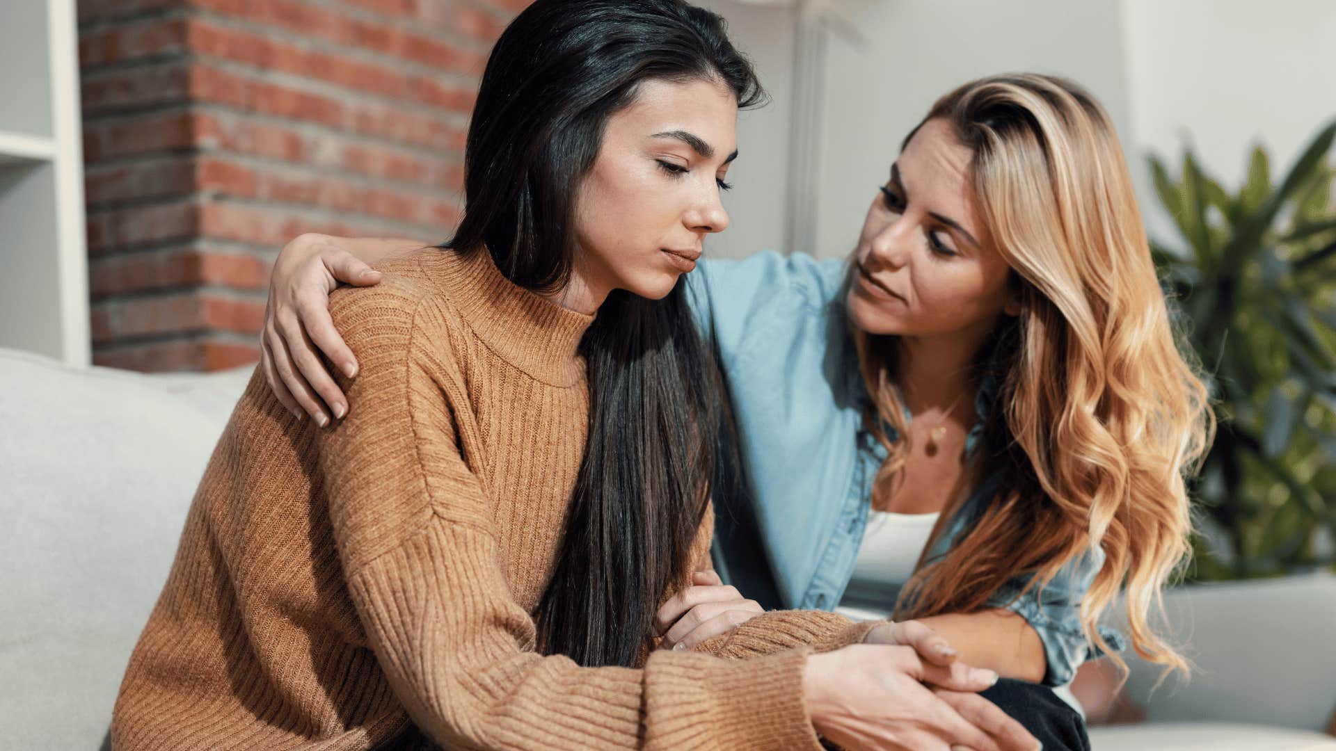 woman comforting friend on couch