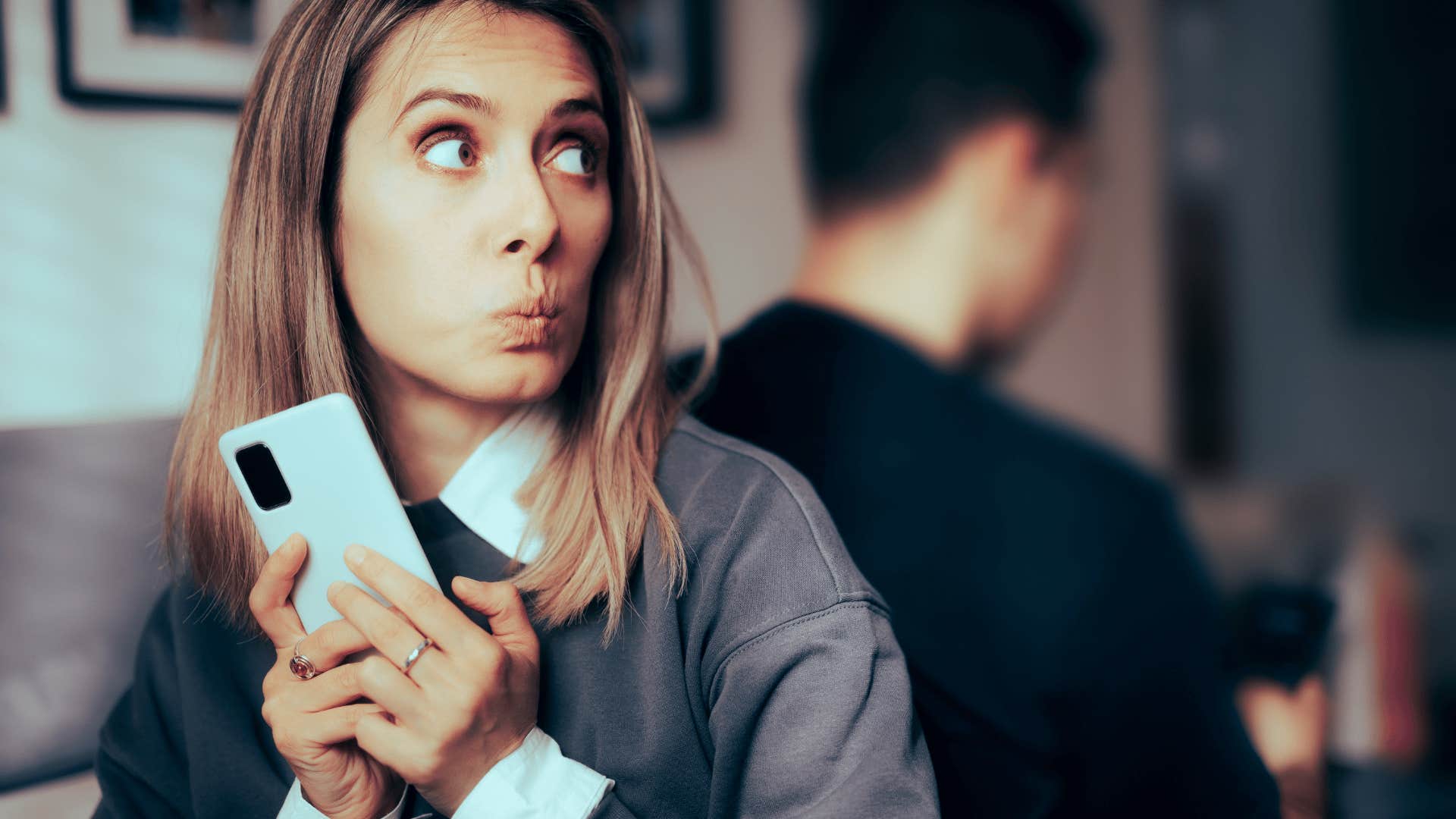 woman hiding phone from partner