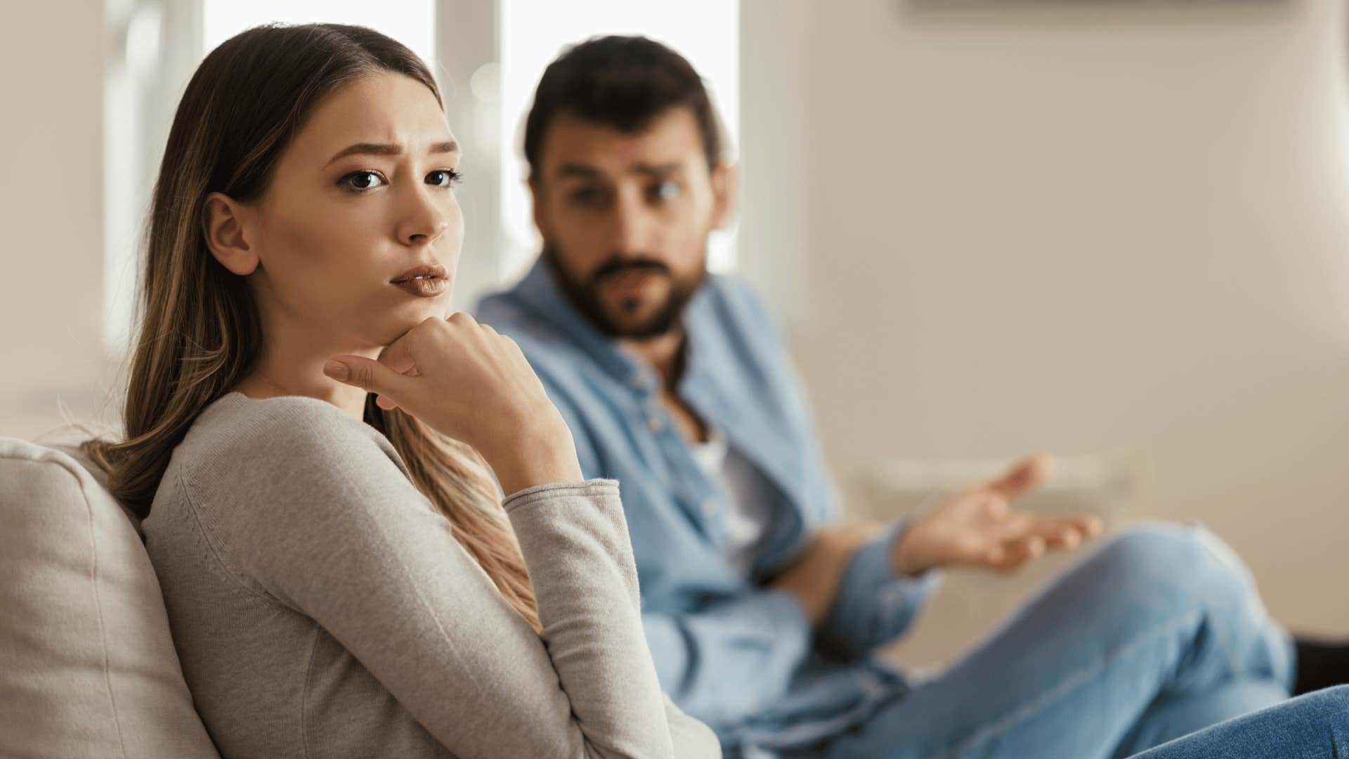 man trying to talk to partner on couch