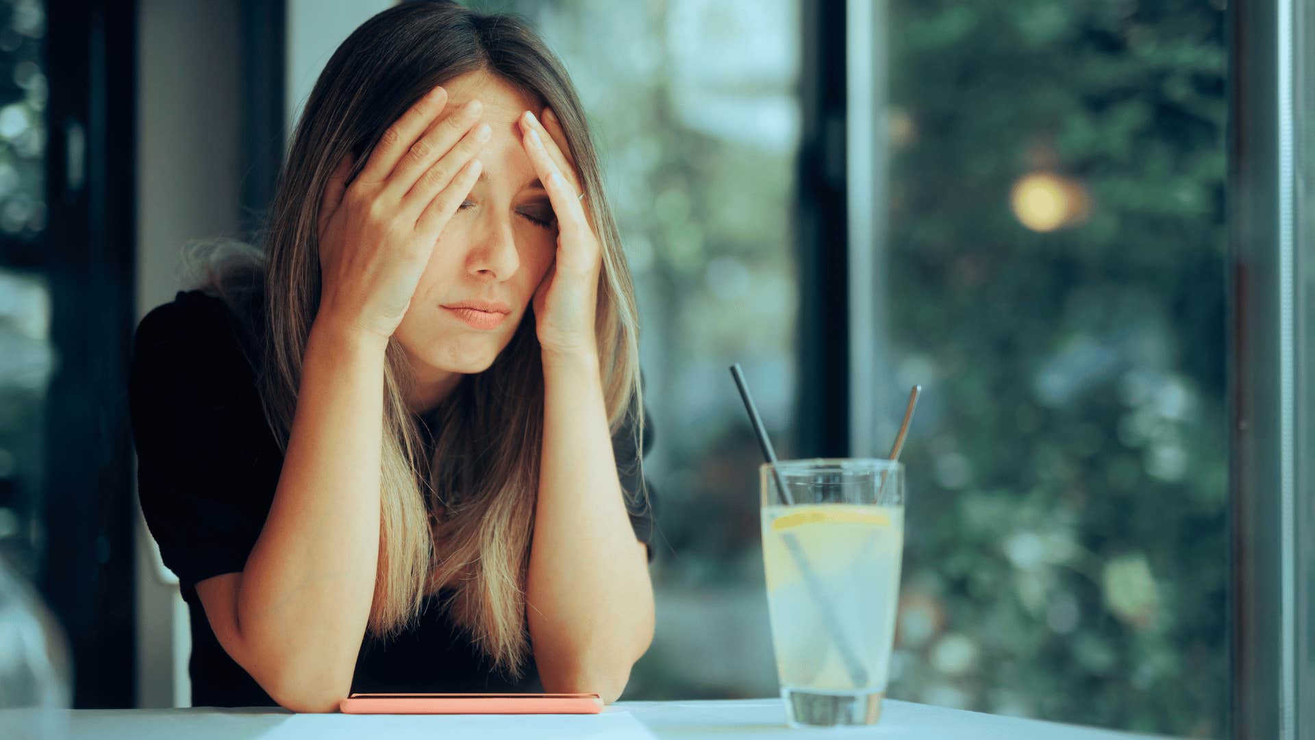 sad woman covering her face with her hands