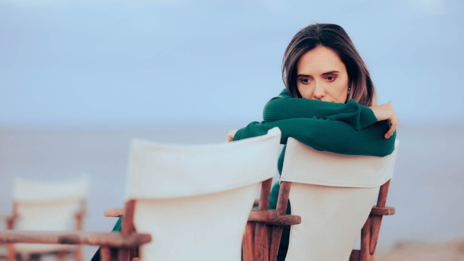 woman sitting on chairs on beach alone