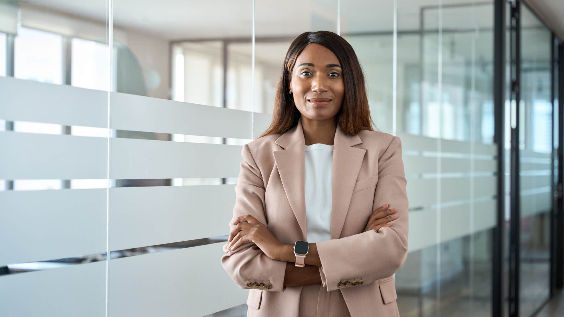 woman with arms crossed standing in office