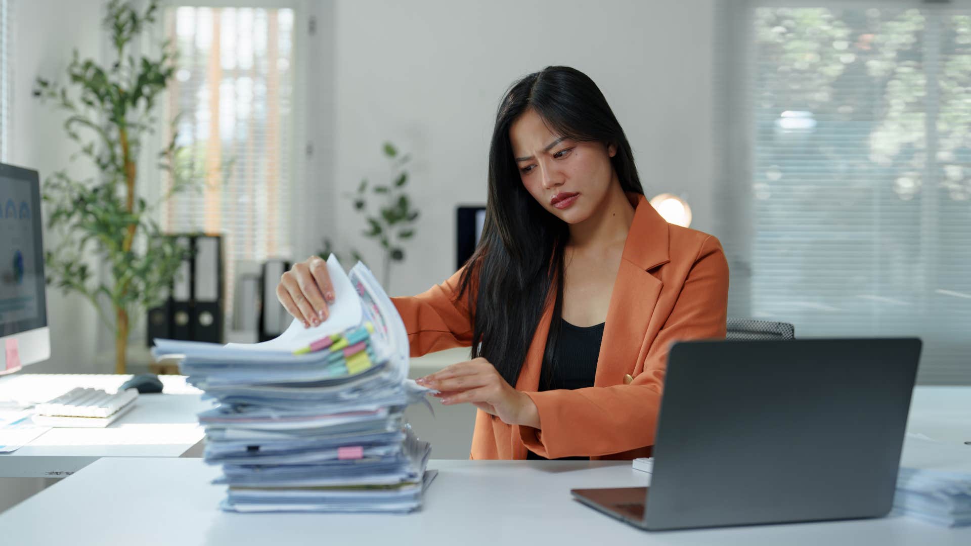 stressed woman sifting through paperwork