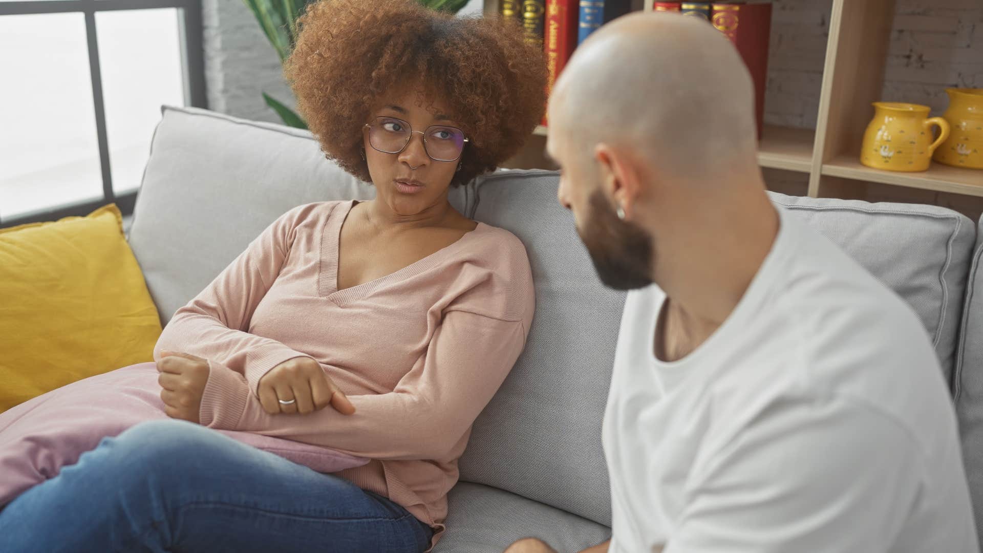 woman looking annoyed while her husband speaks