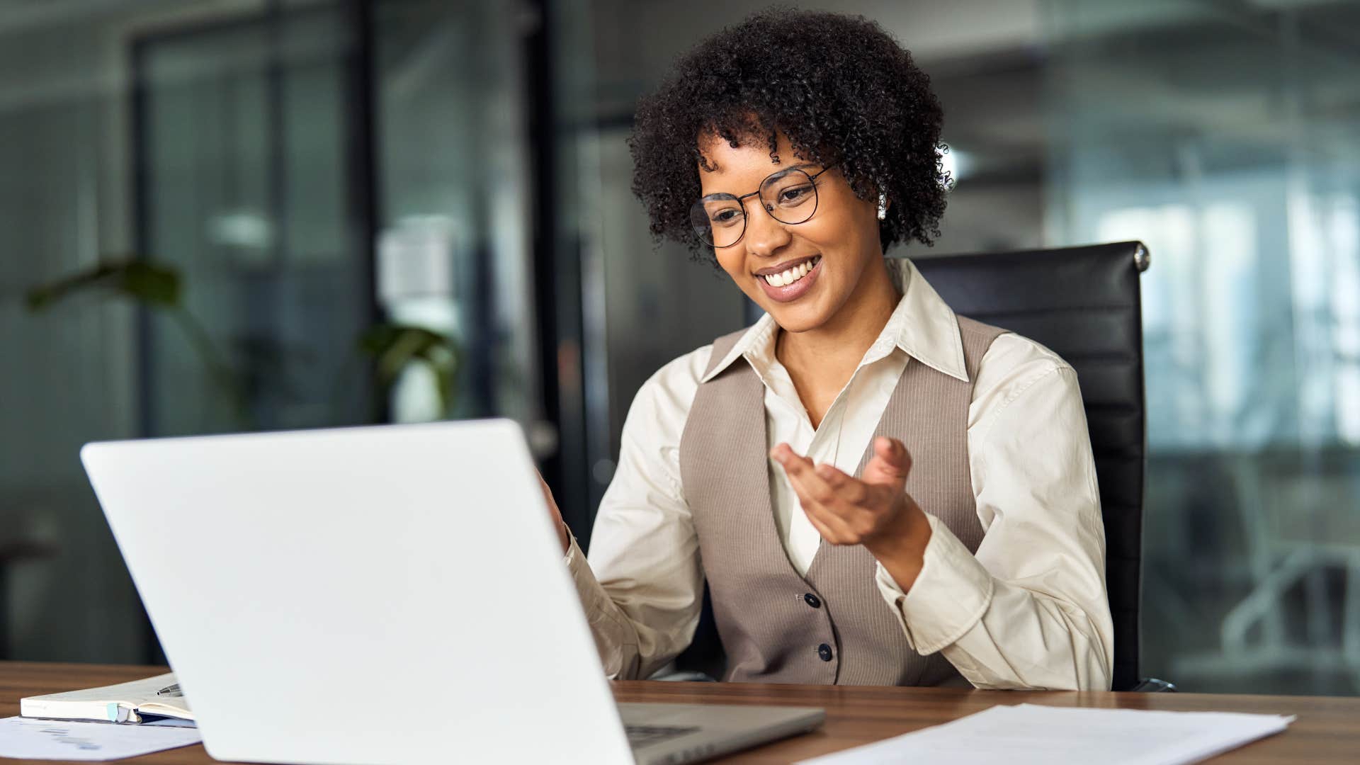 Woman smiling and talking to someone on her laptop