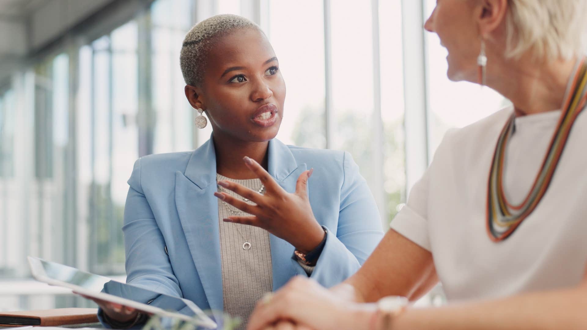 Professional woman talking to a peer at work