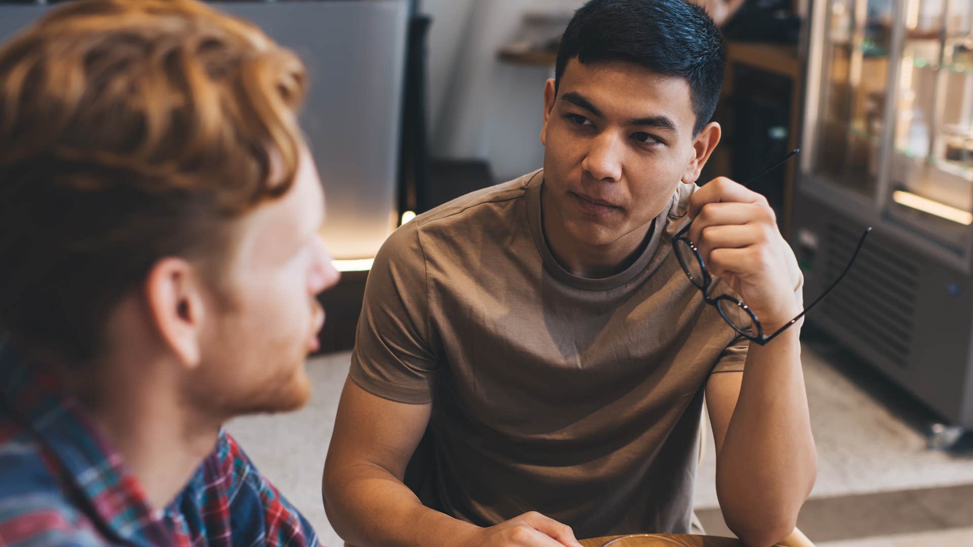 Two men having a serious conversation in a coffee shop