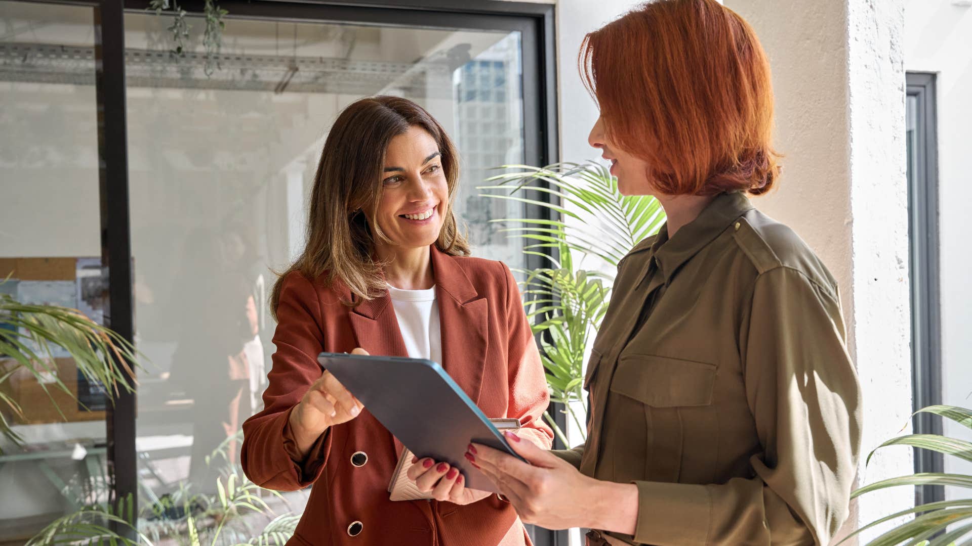 Two women smiling and talking at work