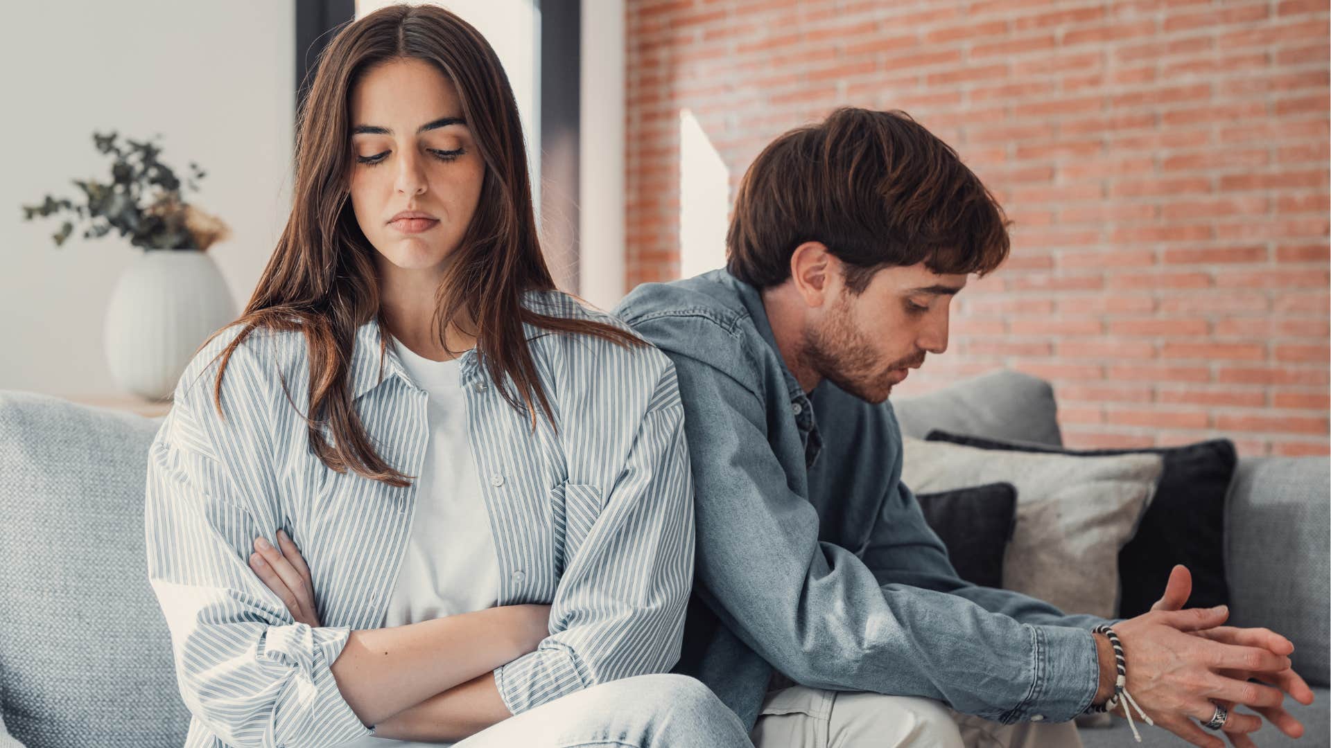 Angry couple sitting next to each other on a couch