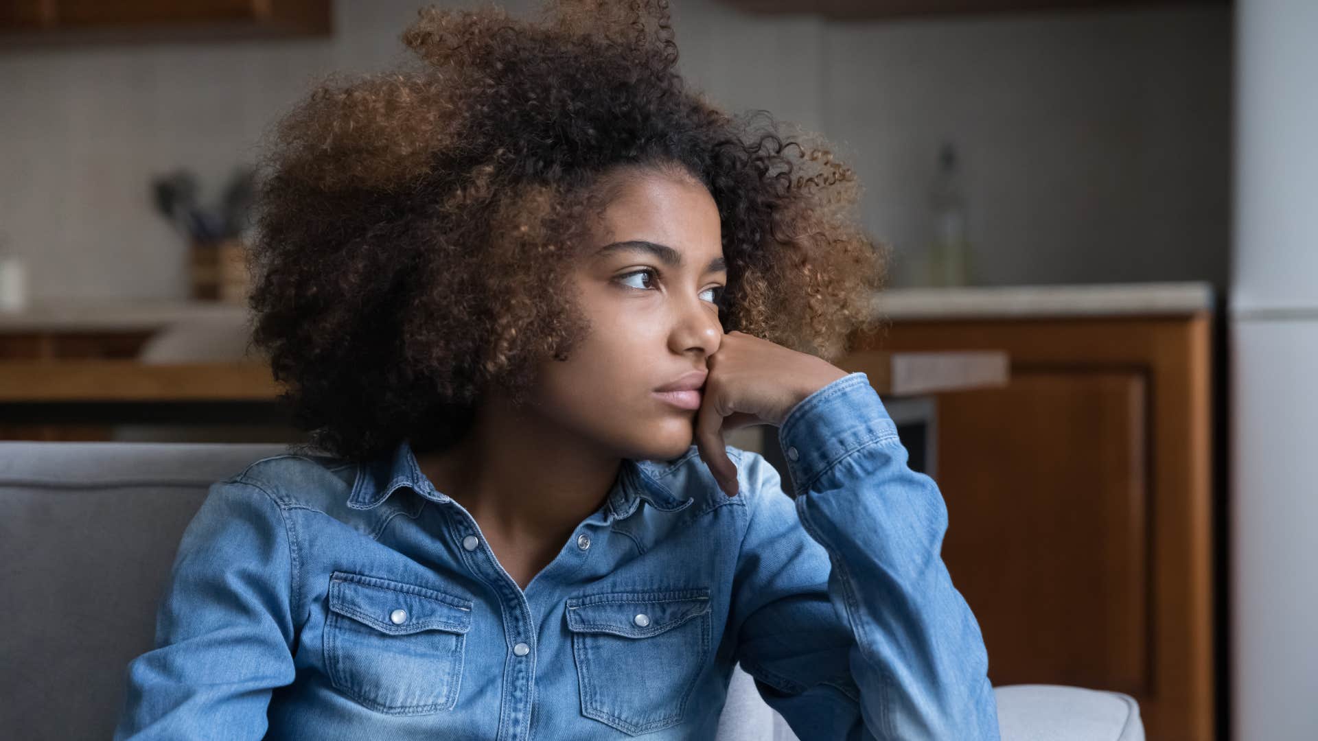 woman sitting on couch deep in thought