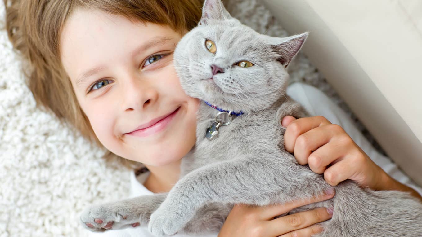 little boy hugging affectionate cat