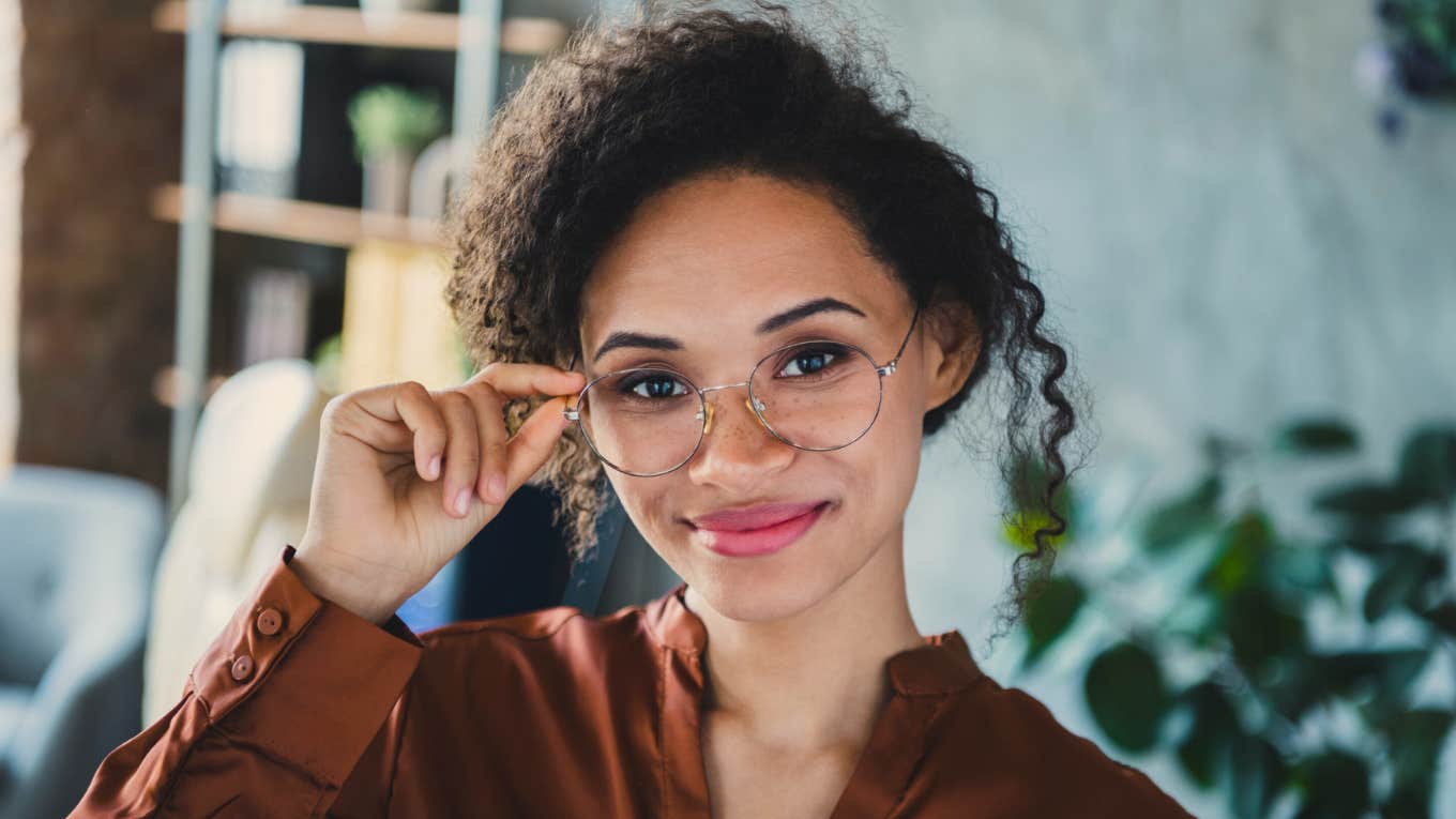 intelligent woman smiling holding her glasses