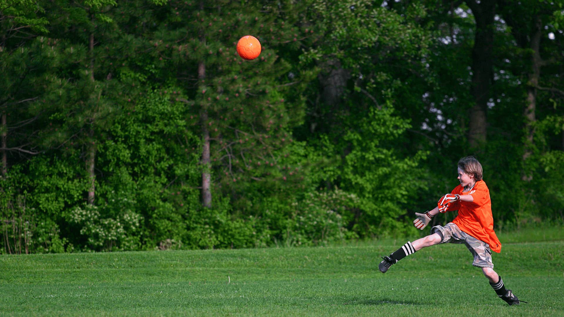 boy playing kickball