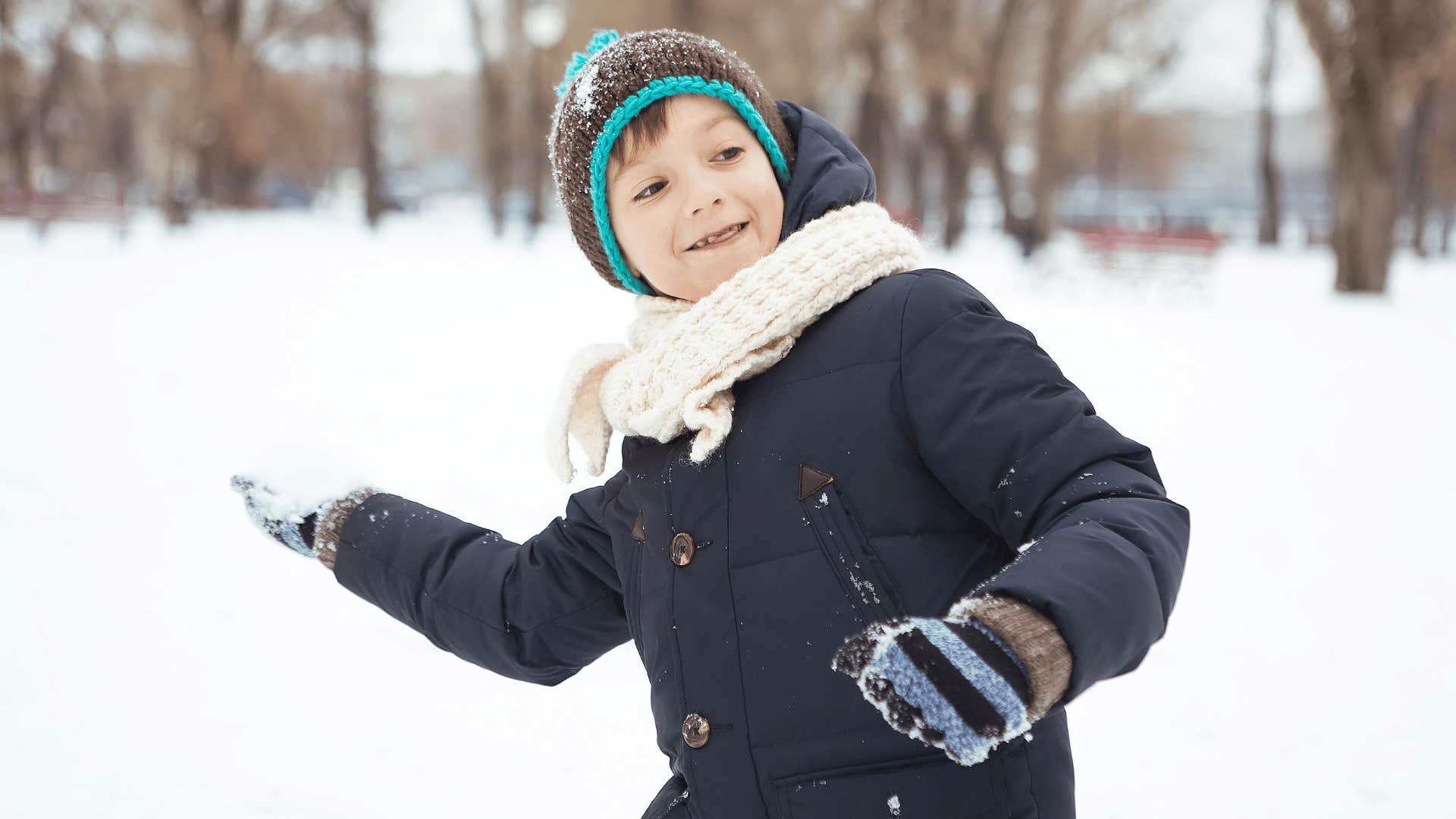 kid preparing for a snowball fight