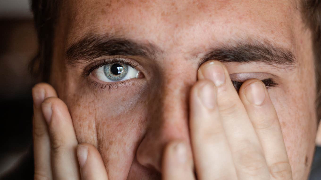 sad man covering his face with his hands