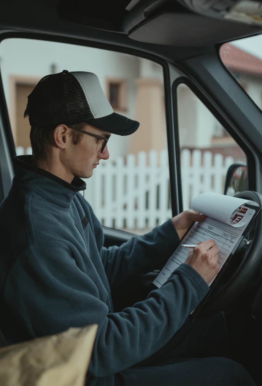 Amazon delivery driver checking special delivery instructions from customer