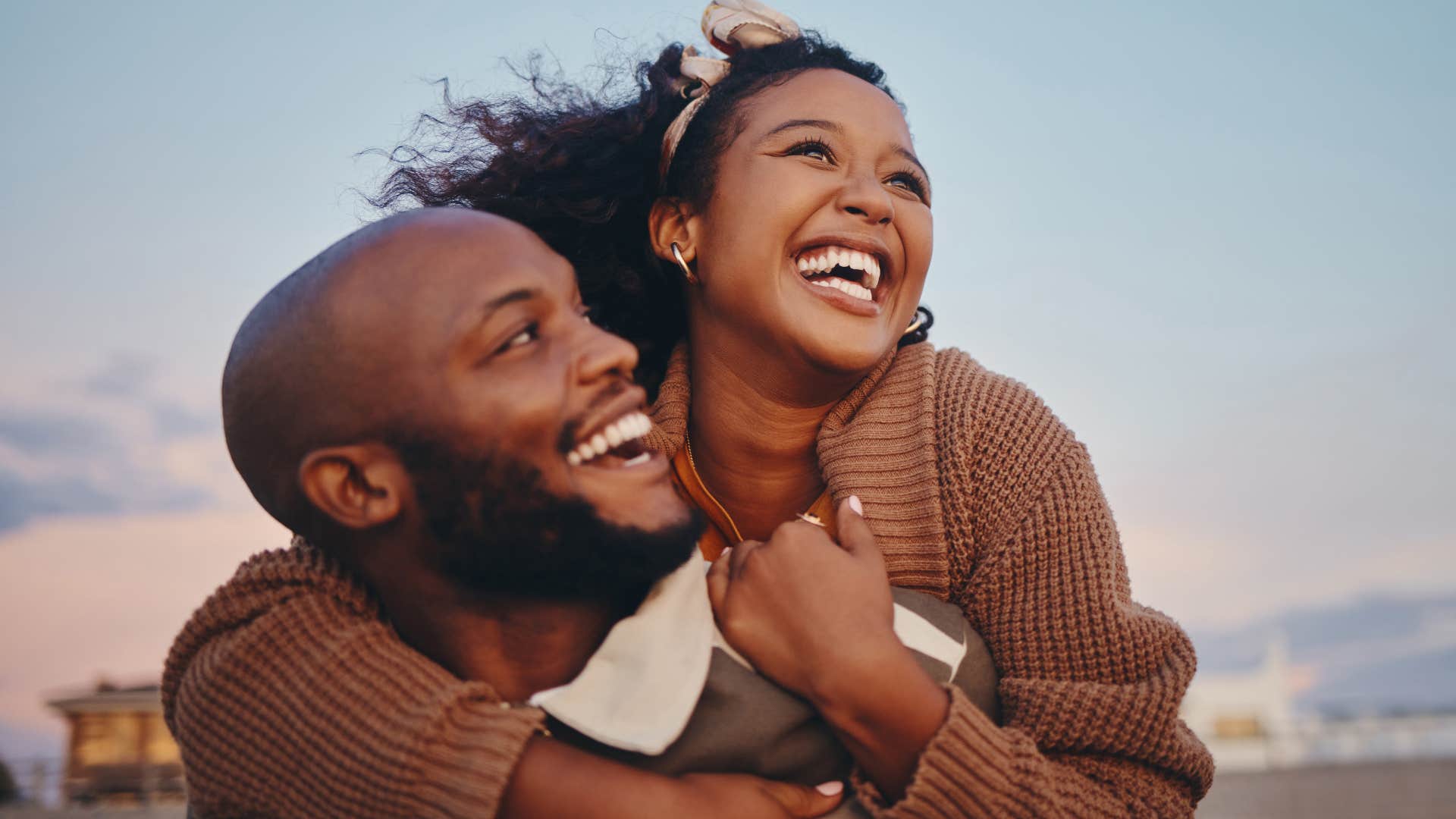 Smiling couple hugging on a beach.