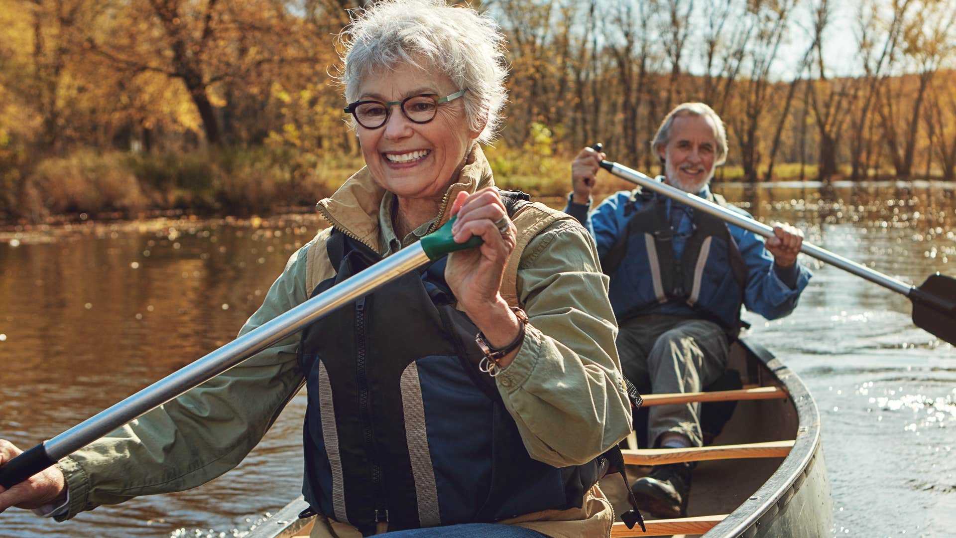 Woman smiling sitting in front of her husband in a canoe.