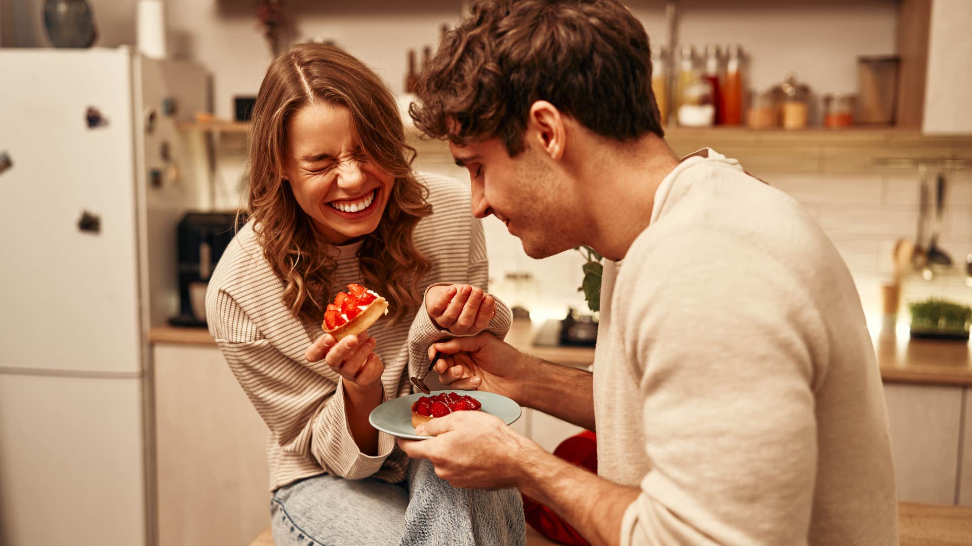 Man smiling and eating a dessert with his wife.