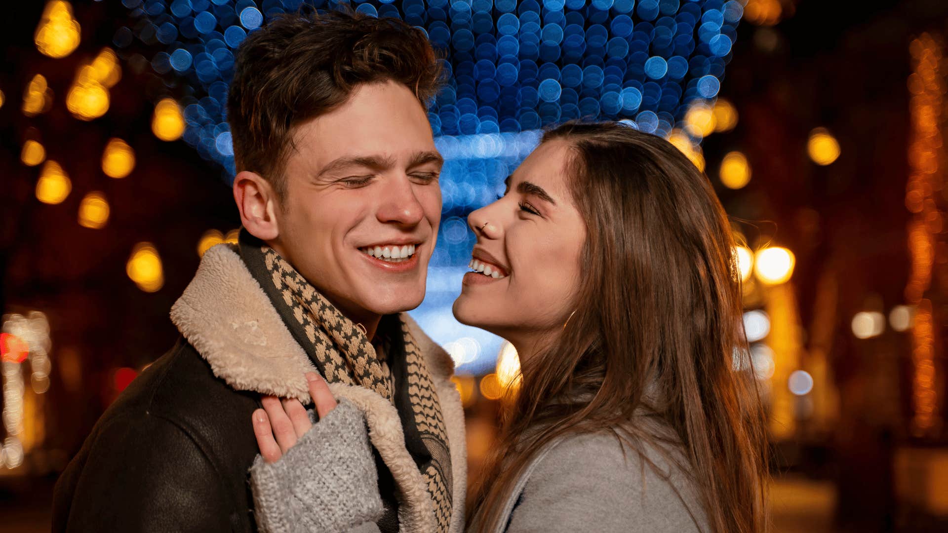 happy smiling couple outside with lights