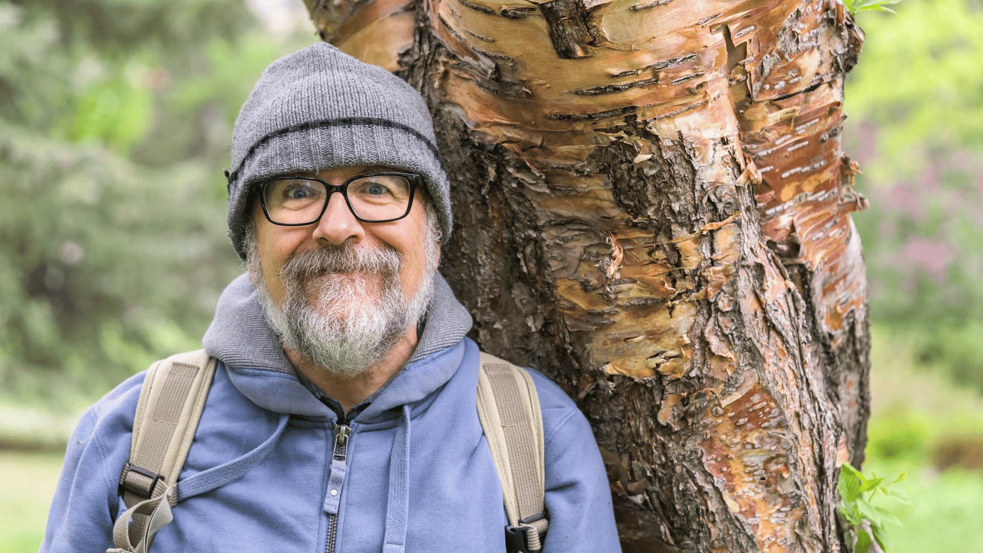 boomer man standing in front of a tree