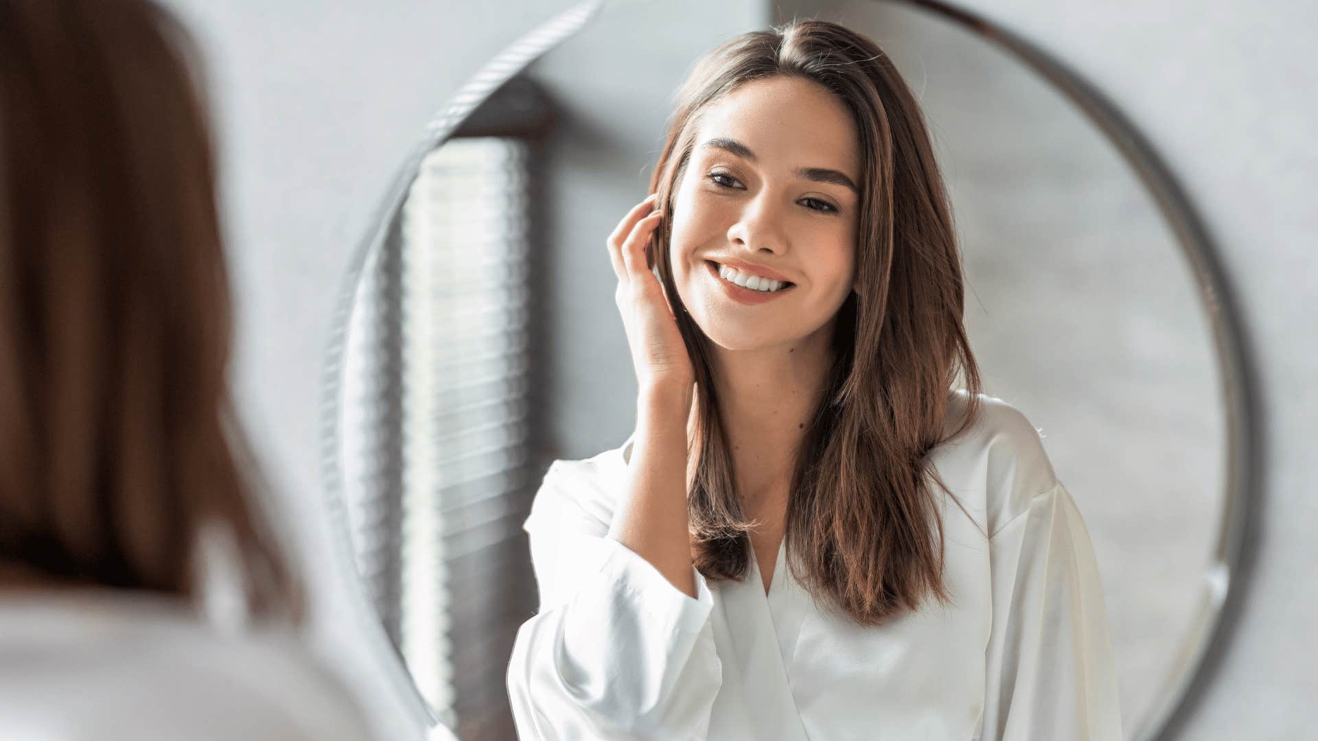 woman touching her face in mirror